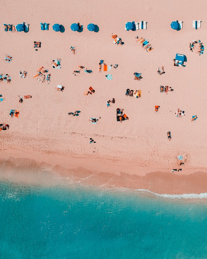People relaxing on a sunny beach, representing summer wellness, seasonal living, and Traditional Chinese Medicine-inspired self-care, healthy eating, and balance.